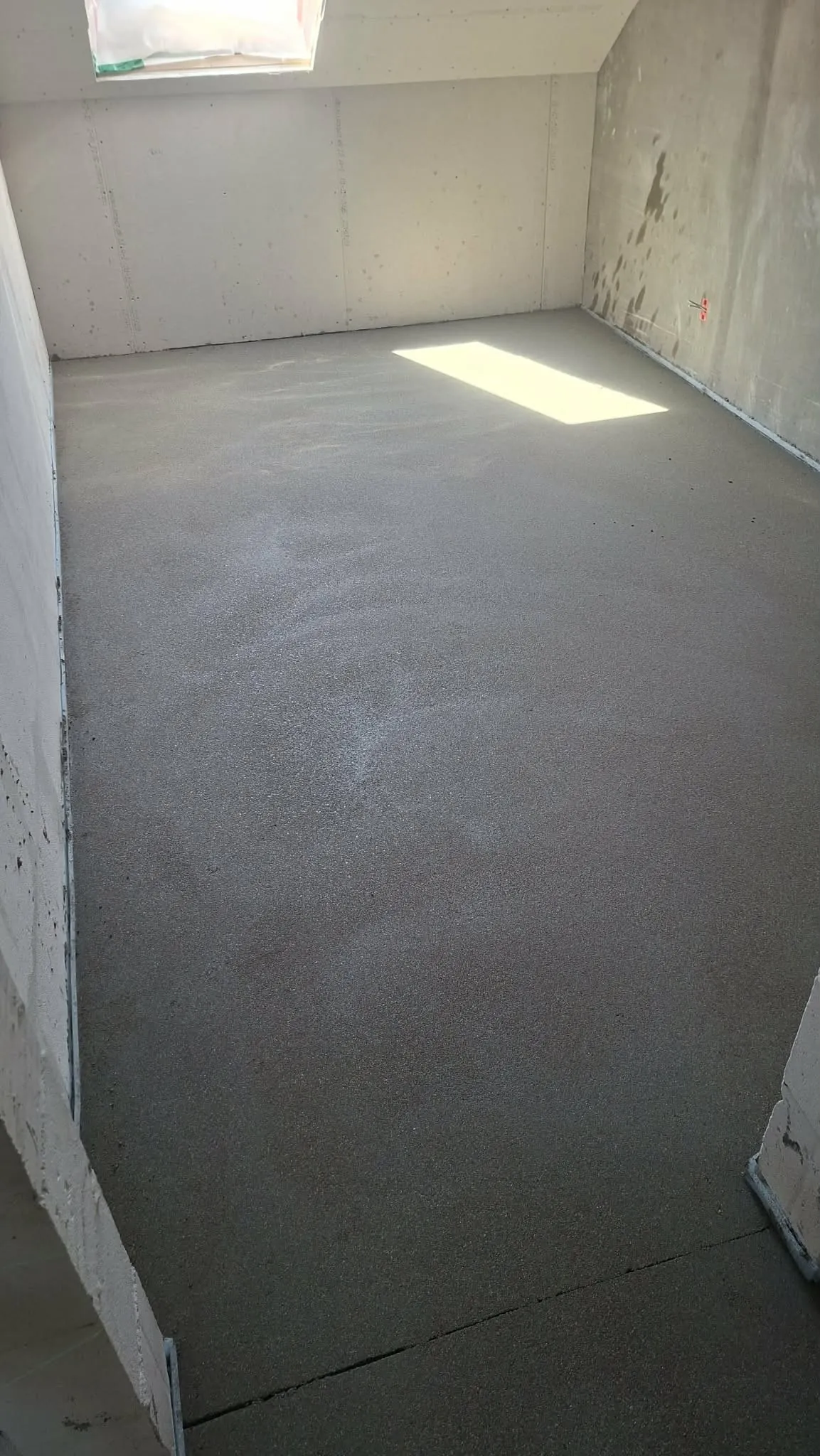 Finished floor screed in an attic room with a roof window